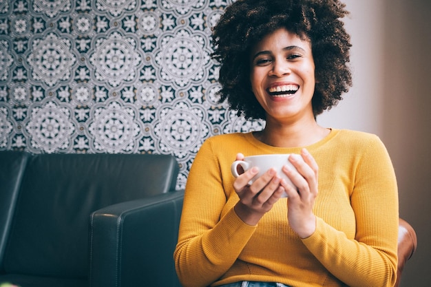 Foto ritratto di una giovane donna sorridente che usa un telefono cellulare