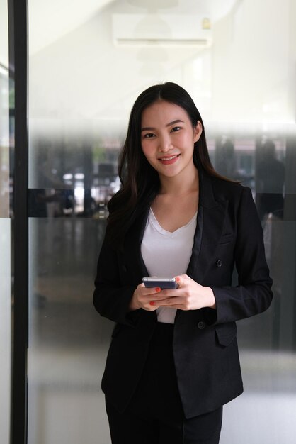 Portrait of a smiling young woman using smart phone