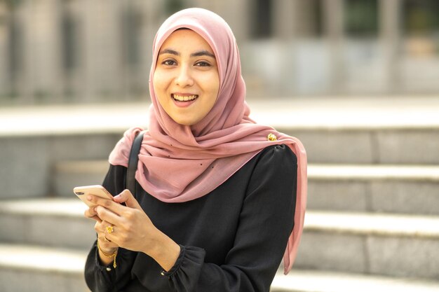 Portrait of a smiling young woman using smart phone