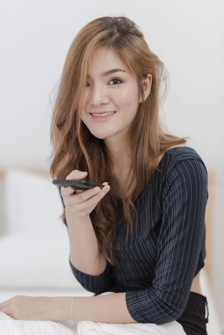 Photo 一個微笑的年輕女人用智能手機的肖像