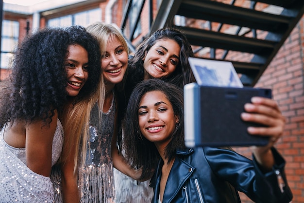 Foto ritratto di una giovane donna sorridente che usa uno smartphone