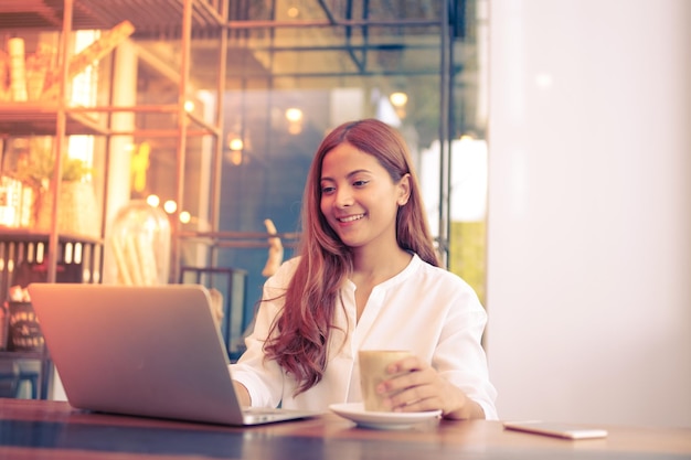 portrait of smiling young woman using smart phone
