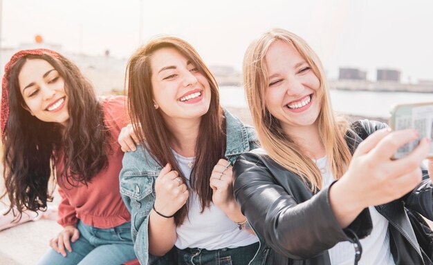 Foto ritratto di una giovane donna sorridente che usa uno smartphone