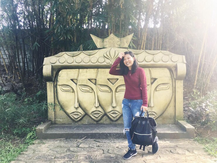 Photo portrait of smiling young woman walking against carvings