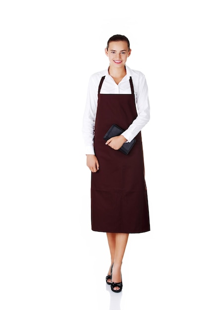 Photo portrait of smiling young woman wearing apron while standing against white background