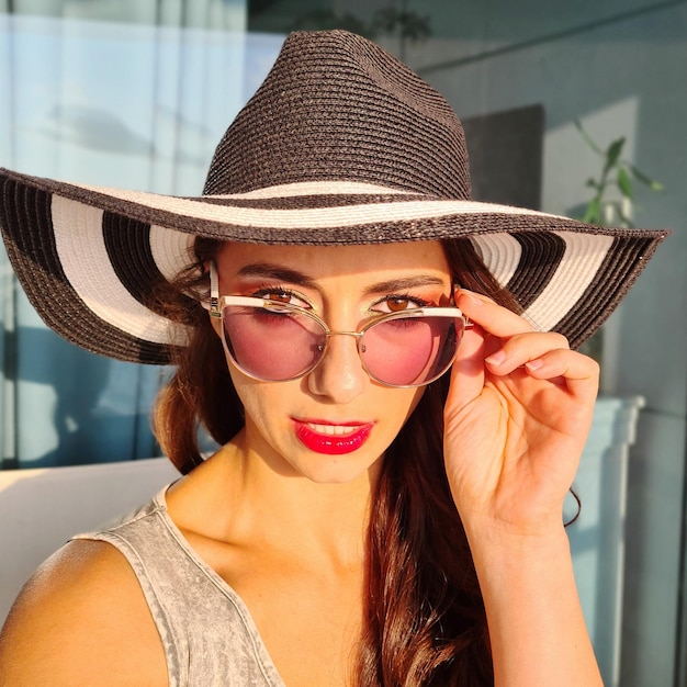 Foto ritratto di una giovane donna sorridente che indossa un cappello