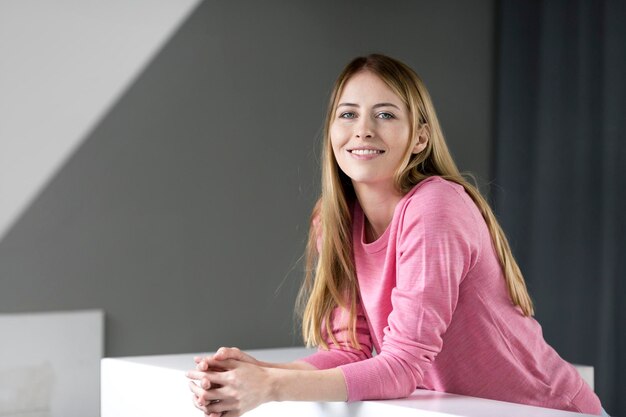 Portrait of smiling young woman wearing pink pullover