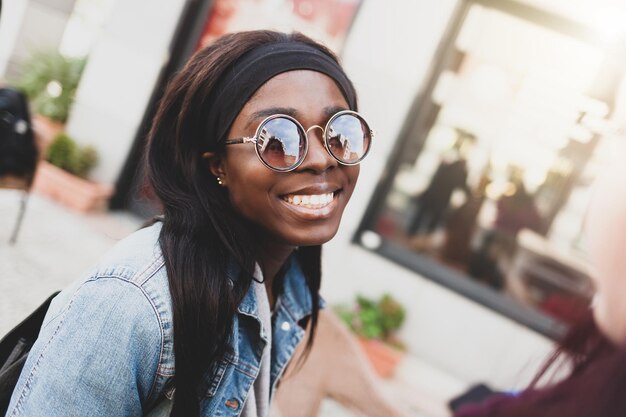 Photo portrait of smiling young woman wearing sunglasses