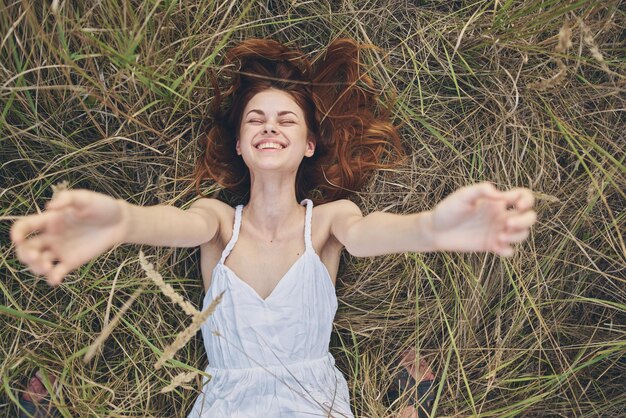 Foto ritratto di una giovane donna sorridente con le braccia alzate sul campo