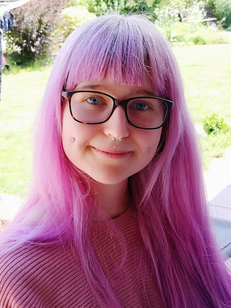 Foto ritratto di una giovane donna sorridente con i capelli colorati