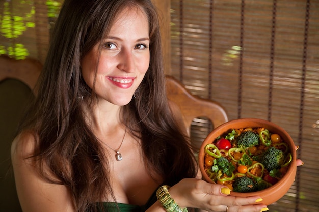 Portrait of smiling young woman with vegetables