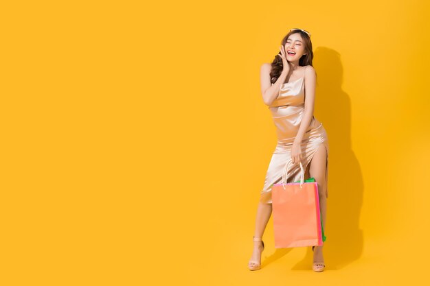 Portrait of a smiling young woman over yellow background