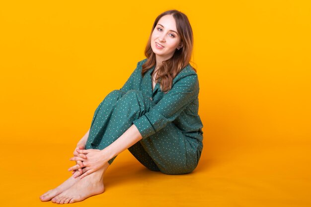 Portrait of a smiling young woman over yellow background