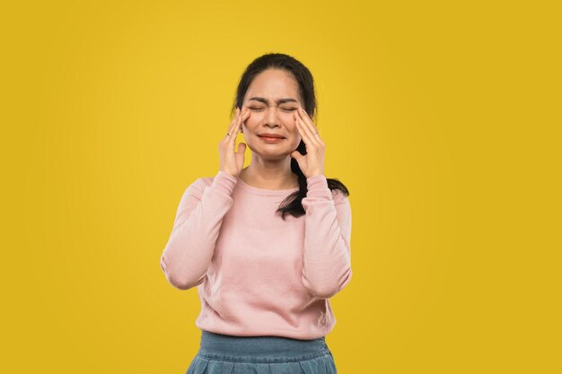 Portrait of a smiling young woman over yellow background