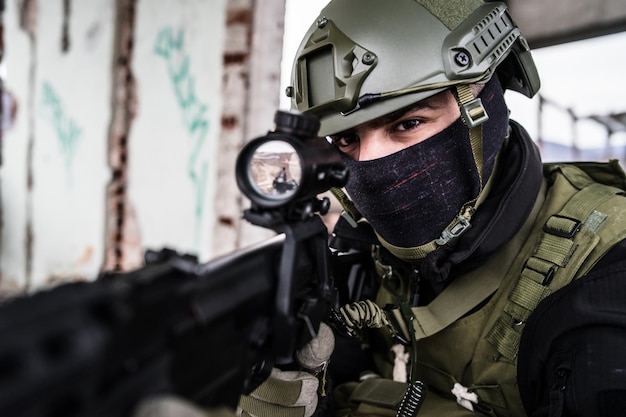 Photo portrait of sniper aiming rifle while standing outdoors