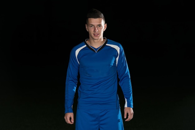 Portrait Of A Soccer Player And Ball On Football Stadium Field Isolated On Black Background