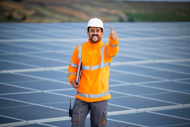 Portrait of solar power plant engineer with laptop computer controlling sustainable energy