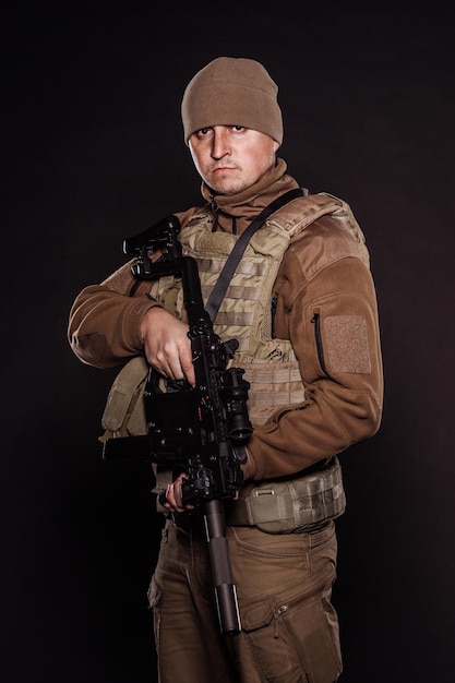 Portrait soldier or private military contractor holding rifle