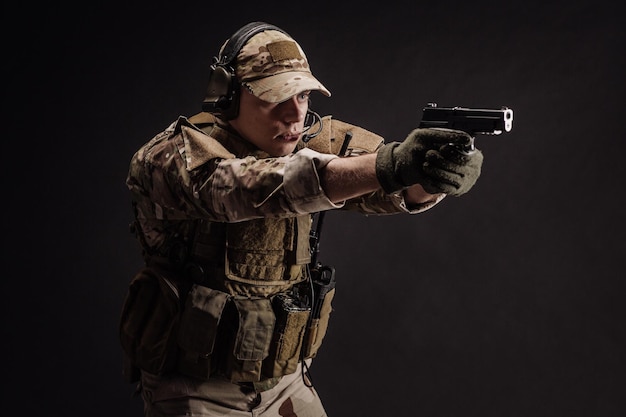 Портрет солдата или частного военного подрядчика, держащего в руках снайперскую винтовку, военное оружие, военные технологии и концепцию людей. Изображение на черном фоне