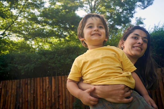 Photo portrait of son with his mother playing outdoors