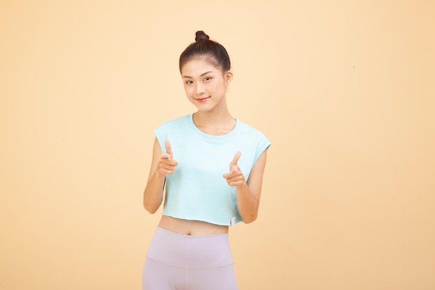 Photo portrait of south east asian young beautiful cheerful lady with hand gesture pointing something isolated on background