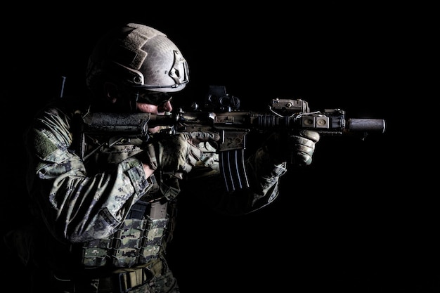 portrait of special forces soldier in field uniforms with weapons, portrait on black