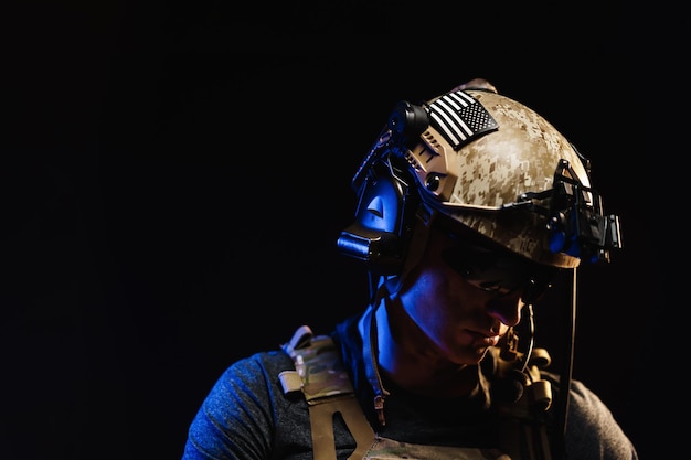 Photo portrait of special forces soldier in helmet and glasses in the dark