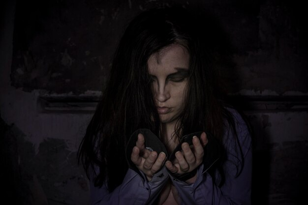 Portrait of spooky woman against wall