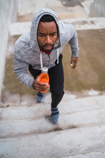 Portrait of a sport man running up on stairs outdoors. Fitness, sport and healthy lifestyle concepts.