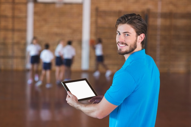 Portrait of sports teacher using digital tablet