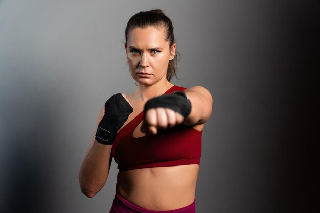 Portrait of a sporty female boxer on a grey background