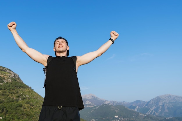 Portrait of a sporty man who enjoys successful hiking in the mountains Stunning landscape around