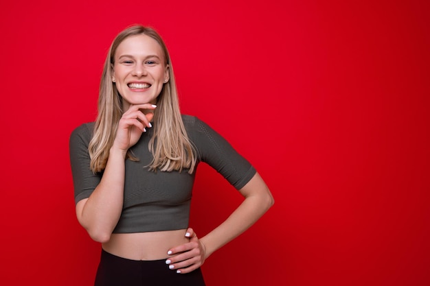 Portrait of a sporty young woman on a red backgroundStudio sports photography