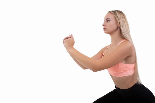 Portrait of a sporty young woman in a training uniform doing exercises