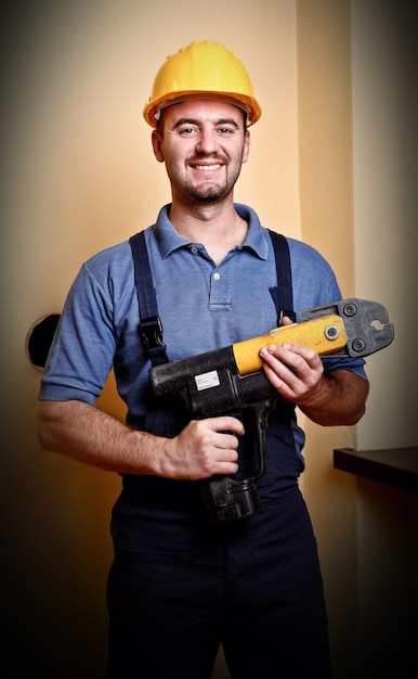 Портрет постоянного работника физического труда, держащего электрический инструмент