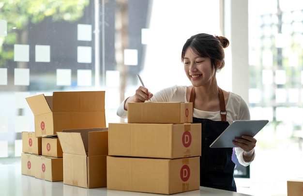 Portrait of Starting small businesses SME owners female entrepreneurs working on receipt box and check online orders to prepare to pack the boxes sell to customers sme business ideas onlinexA