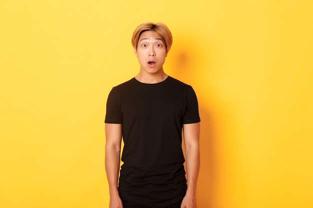 Portrait of startled handsome asian blond guy