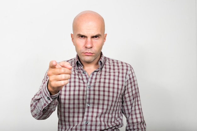 Photo portrait of stressed bald businessman pointing at camera