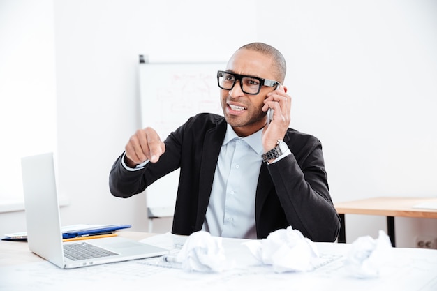 Portrait of a stressed businessman talking on phone in office