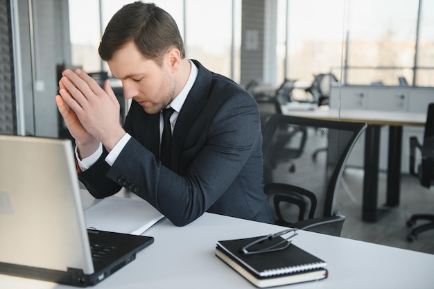 Portrait of stressed out and worried troublesome overworked businessman entrepreneur looking documents report in modern bright office working under pressure and tight deadline