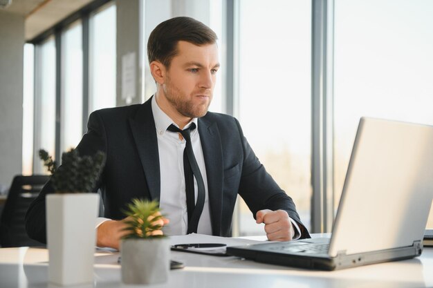 Portrait of stressed out and worried troublesome overworked businessman entrepreneur looking documents report in modern bright office working under pressure and tight deadline