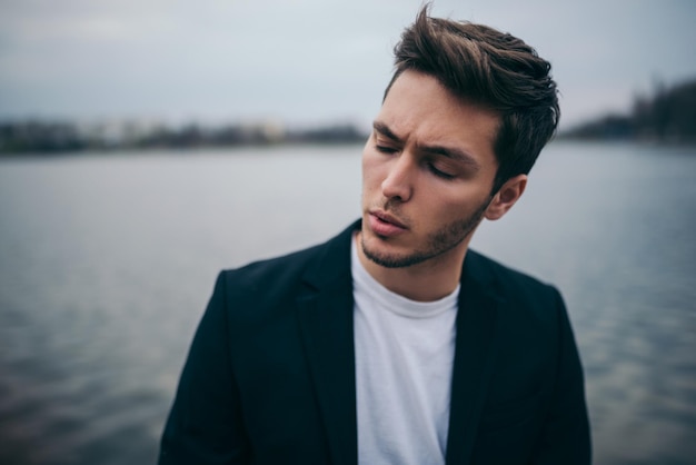 Portrait stressed young sad man wearing casual suit in the park outdoor background Negative human emotion facial expression feeling Social issues concept