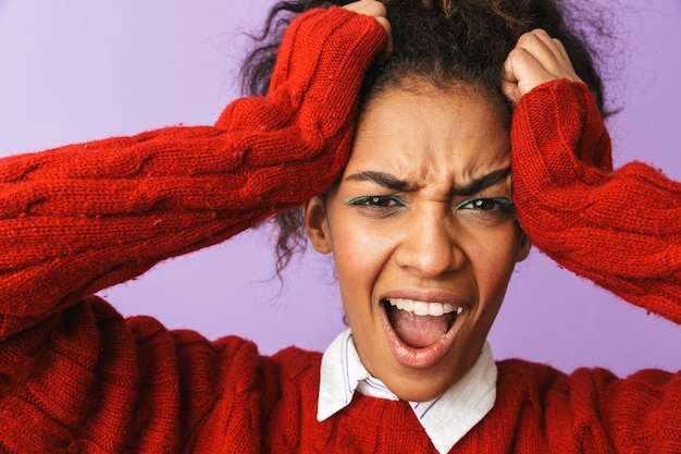 Photo portrait of stressful african american woman with afro hairstyle screaming and grabbing head, isolated