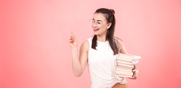 Portrait of a student girl with glasses with books in her hands. Concept of education and Hobbies.