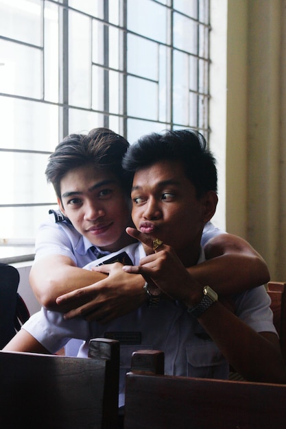 Photo portrait of student with friend in classroom