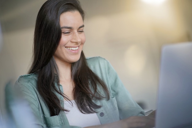 Portrait of stunning brunette smiling at her laptop                                                      