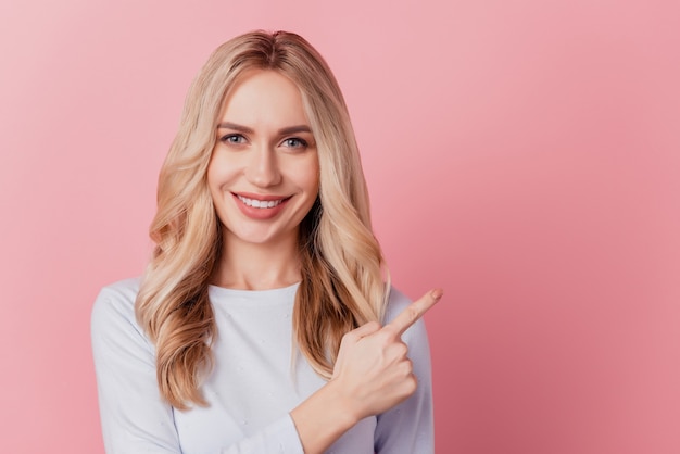 Portrait of stunning promoter lady direct forefinger empty space on pink background