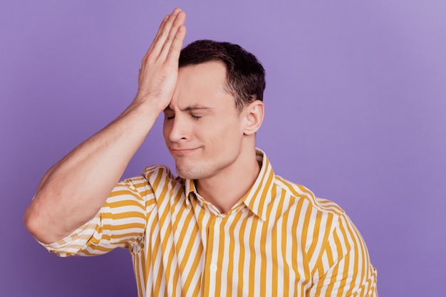 Photo portrait of stupid guy hit head palm forget make mistake on purple background