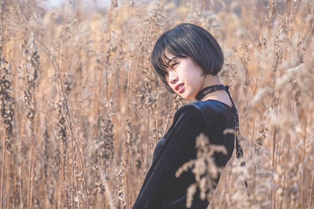 portrait of style woman standing amidst reed field,China.