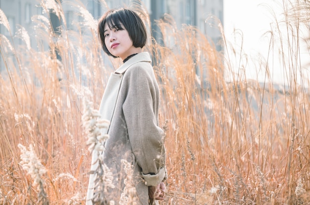 portrait of style woman standing amidst reed field